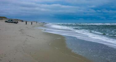 Fishermen on the sandy shore of the Atlantic Ocean in New Jersey, USA photo