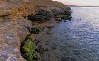Rocky cliff shore, destroyed by sea waves in the Crimea photo