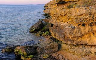 Rocky cliff shore, destroyed by sea waves in the Crimea photo