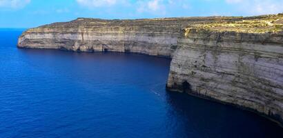 High vertical rocky shore on the island of Gozo, Malta photo