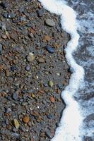 Kara-Dag, a round sea-rolled pebble from a volcanic rock on a pebble beach, Crimea photo