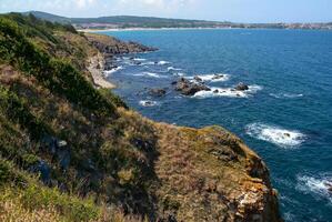 Seascape on the Black Sea, high steep stone coast with inaccessible rocks photo