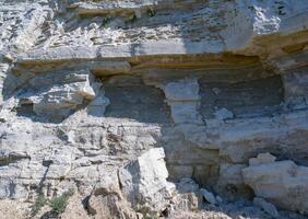 Vertical high rock made of white shell rock near the Black Sea coast near Sozopol, Bulgaria photo