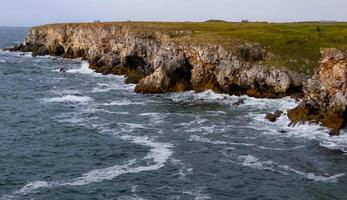 Seascape on the Black Sea, high steep stone coast with inaccessible rocks photo
