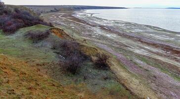View of the shore of the shallowed and frozen Tiligul estuary in winter photo