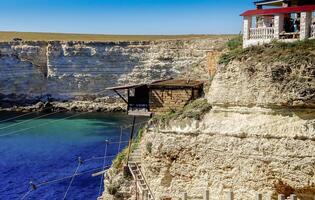 OLENEVKA, CRIMEA - JUNE 21, 2016 - Fisherman's house on the rocks for observing schools of mullet photo