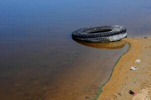 Car tires on the shore Hadzhibeysky estuary. Eutrophication of the reservoir, the problem of ecology photo