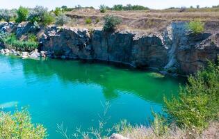 View of the flooded granite quarry with turquoise clear water, Ukraine photo