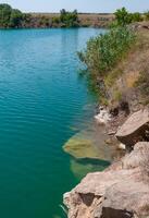 View of the flooded granite quarry with turquoise clear water, Ukraine photo