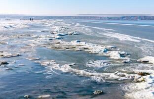 Ice floating near the shore and ice floes on the shore in the Tiligul estuary in winter, Ukraine photo