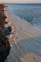 Wavy Dirty foam driven by the wind to the shore of the Tuzlovsky estuary photo