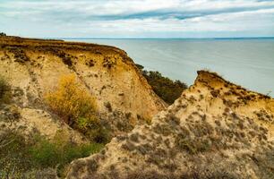 Clay shores of the Dniester estuary, steep with ravines, overgrown with wild steppe vegetation photo