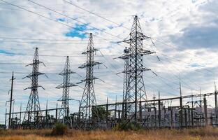 High-voltage lines on steel structures with wires against the background of the sky with clouds photo