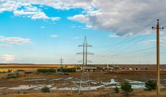 High-voltage lines on steel structures with wires against the background of the sky with clouds photo