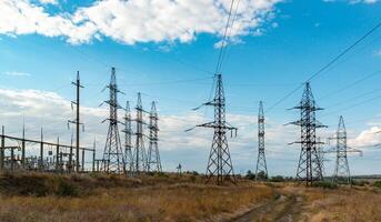 High-voltage lines on steel structures with wires against the background of the sky with clouds photo