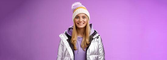 Amused fascinated attractive excited blond woman stepping skis first time feel temptation thrill joyfully smiling widen eyes impressed cannot wait learn snowboarding standing silver jacket photo