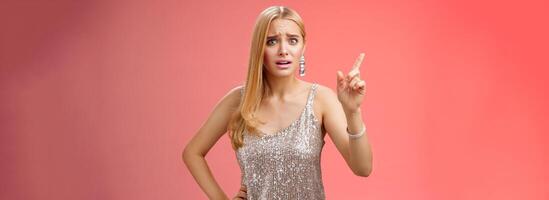 How could you. Disappointed let down upset complaining young woman demanding respect raise index finger scolding teaching lesson give instructions standing bothered displeased, red background photo