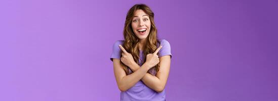Lively surprised charismatic curly girl fascinated look admiration joy picking between awesome opportunities amazed excellent choices pointing sideways left right make decision purple background photo