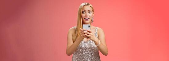Panicking shocked woman concerned photos leaked internet look afraid anxious widen eyes cringing troubled hold smartphone shook speechless gasping terrified friends find out secret, red background