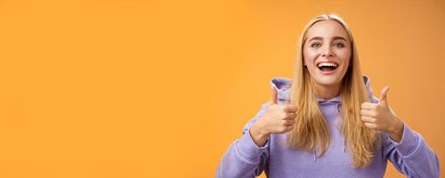 Supportive cute blond girlfriend cheering liking interesting concept cool idea thumbs-up smiling broadly agree approve outfit shopping together friends, recommend adore new look, orange background photo