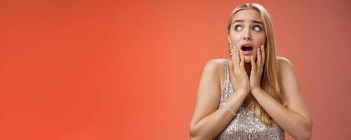 Afraid girl panic look left scared trembling fear insecure touching cheeks helpless stare sideways grimacing gasping frightened nervously waiting help, standing concerned red background photo