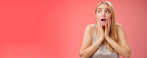 Afraid girl panic look left scared trembling fear insecure touching cheeks helpless stare sideways grimacing gasping frightened nervously waiting help, standing concerned red background photo