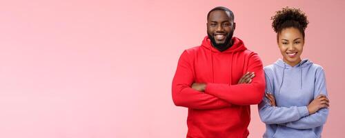 Charming happy professional team two african american man girl smiling broadly self-assured own abilities cross arms chest grinning friendly unbeatable working together, standing pink background photo