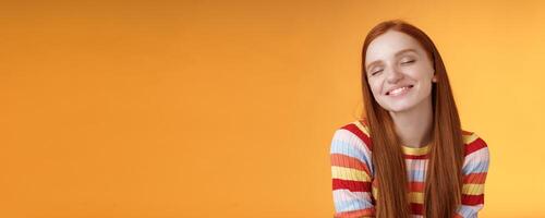 Tender sensual dreamy cute redhead feminine girl dreaming about tasty slice pizza close eyes smiling delighted drooling standing fascinated mesmerized recalling lovely moment, orange background photo