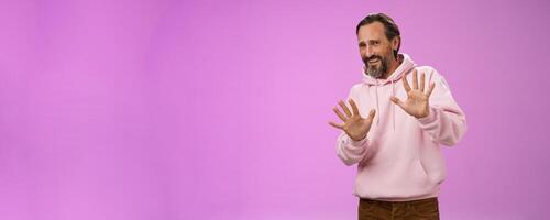 Stop no not come closer. Portrait awkward insecure afraid mature bearded man asking stop enough showing palms raised begging quit refusing step back displeased, standing unconfident photo