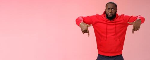 Questioned displeased pissed handsome serious-looking athletic black guy bearded frowning look perplexed wondered freak out pointing down waiting explanation, standing frustrated pink background photo