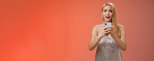 Panicking shocked woman concerned photos leaked internet look afraid anxious widen eyes cringing troubled hold smartphone shook speechless gasping terrified friends find out secret, red background