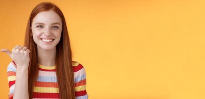 Girl pointing left cool person can help smiling delighted look friendly camera discuss interesting project introduce friend during conversation standing happy grinning orange background photo