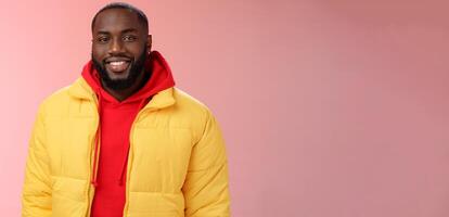 Waist-up happy charismatic good-looking bearded guy in yellow jacket red hoodie smiling joyfully white perfect smile talking have nice friendly conversation, standing pink background photo