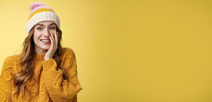 Smiling attractive carefree young 20s woman having fun talking casually nice conversation girlfriend press palm cheek amused blushing receive flirty compliment, standing positive yellow background photo