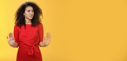 Girl unwiling got in troubles rejecting suspicious and doubtful offer pulling raised palms in no and refusal gesture turning head with grimace from aversion and disgust looking with contempt at camera photo