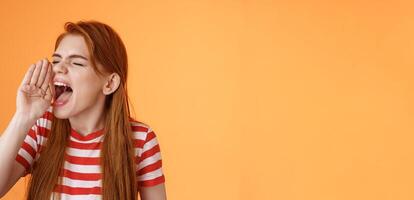 Hey where are you. Cute carefree redhead funny girl hold hand near opened mouth turn left close eyes, yelling out loud, searching someone, calling friend come upstairs, look for person distance photo