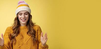 Attractive tender girl retelling friends what got b-day present describing large present box smiling happily look down shaping big thing talking joyfully excited, standing happy yellow background photo