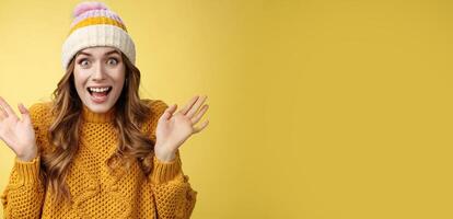 Close-up surprised excited astonished attractive female screaming happily raise hands wondered amazed winning lottery hear awesome perfect news, celebrating smiling broadly, yellow background photo