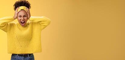 Furious outraged pissed insane african-american girl go crazy freak-out yell shouting agressive look annoyed fed up touching head grimacing scary dangerous very stressed, yellow background photo
