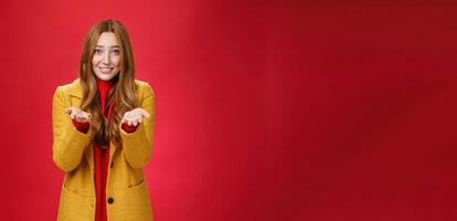 Girl with tender and caring expression smiling extanding hands forward as giving thanks or pointing at someone special feeling admiration thanking partner for support, confessing in love and sympathy photo