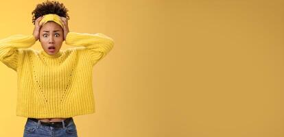 Troubled concerned perplexed female african-american employee duty look complicated panic hold hands head widen eyes shocked face troubles nervously thinking look anxious camera, yellow background photo