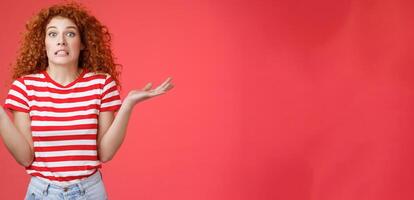 Yikes how should I know. Unaware worried awkward cute redhead curly girl clench teeth smirking uncertain panic cannot answer popping eyes confused shrugging hands spread sideways full disbelief photo