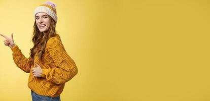Profile shot charismatic flirty good-looking satisfied young girl turn camera pointing index finger left show thumbs-up like gesture approving recommending awesome place yellow background photo