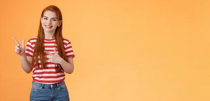 Cheerful pleasant female professional assistant showing customers office, pointing left smiling cheerful, gladly help out pick product, introduce new promos copy space, stand orange background photo