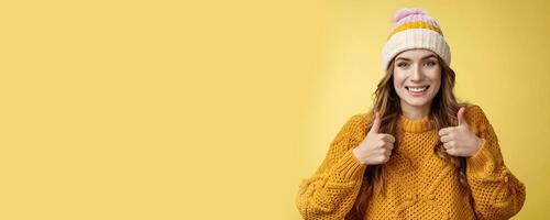 Close-up charming supportive kind young woman show thumbs-up gesture smiling approval liking your idea encourage keep up, satisfied good excellent choice, standing pleased yellow background photo
