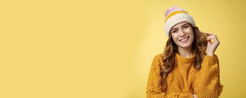 Charming feminine flirty girl seek rich guy during winter vacation mountains ask instructor coquettish teach snowboarding gazing camera seducing rolling curl index finger, yellow background photo