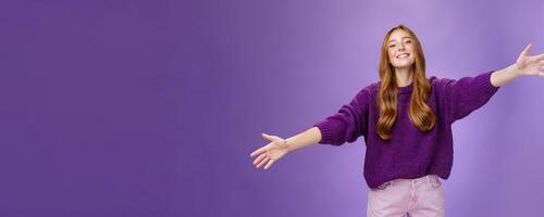 Come into my arms, girl wants give warm hug. Portrait of friendly and cute charming redhead woman stretching hands across copy space and looking forward with happy smile to cuddle and welcome guests photo