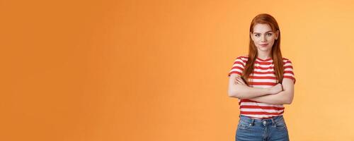 Go on try me. Confident cool redhead daring woman cross arms professional pose, smiling determined motivated win, look assertive and assured own powers, stand orange background photo