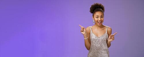 Charming outgoing african-american party girl have fun dancing pointing different sides right left show choices variants smiling broadly asking advice which way go, standing blue background photo