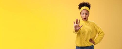 Afraid shocked insecure woman trying show voice be brave extend arm enough stop refusal gesture look frightened insecure unconfident rejecting declining offensive proposal, yellow background photo